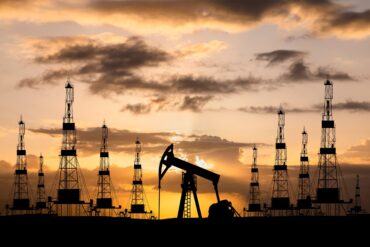 Oil field with rigs and pumps at sunset 1 scaled.jpg